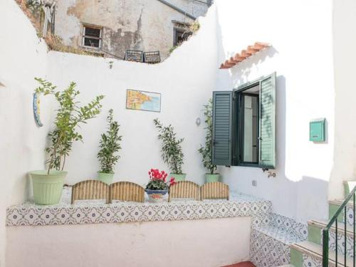 balkon z kwiatami na białej ścianie w obiekcie Casa Annarella w mieście Vietri sul Mare