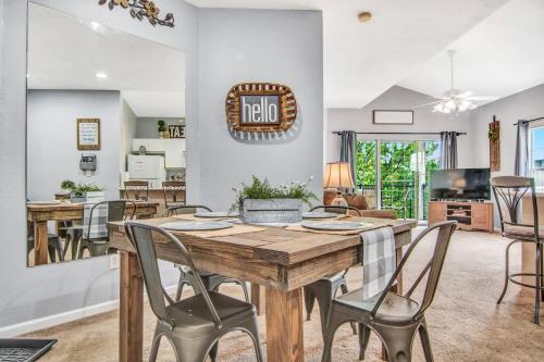 uma sala de jantar e sala de estar com uma mesa de madeira e cadeiras em Hollowed Branch Hideaway Condo em Branson