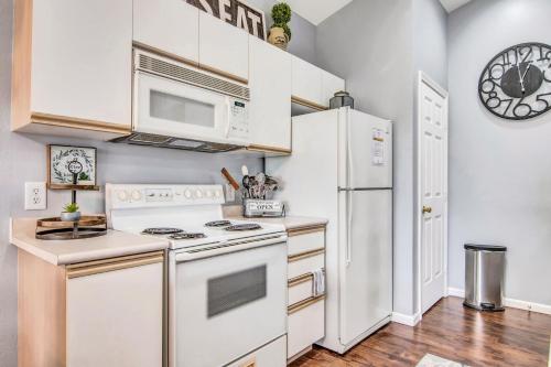 uma cozinha com electrodomésticos brancos e um relógio na parede em Hollowed Branch Hideaway Condo em Branson