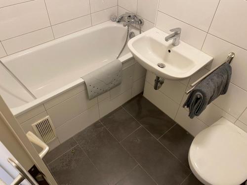 a bathroom with a sink and a tub and a toilet at interaktiv Appartements in Ratingen - Düsseldorferstrasse in Ratingen