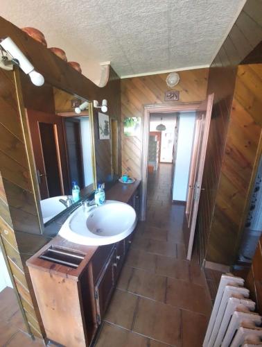 a bathroom with a sink and a large mirror at La casa rosa in Sernio
