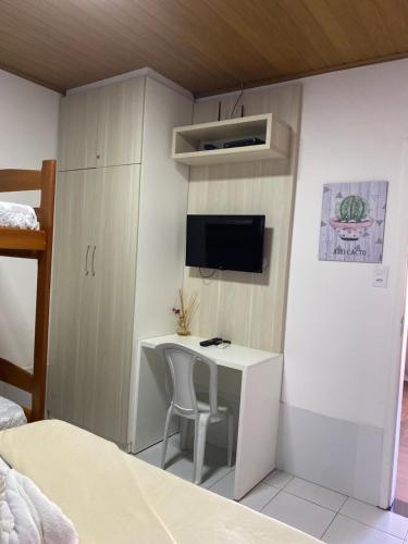 a small room with a desk and a tv at Chalé Temporada Porto dos Lençóis - Lençóis Maranhenses in Barreirinhas