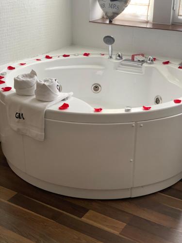 una vasca da bagno bianca con asciugamani in cima di GIA Suites a Caracal