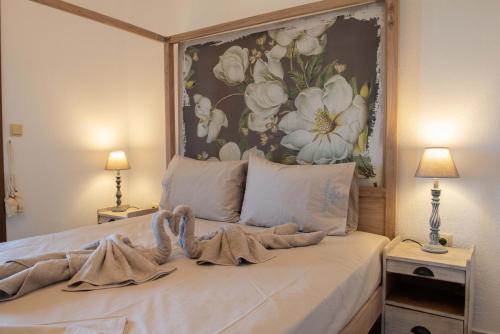 a bedroom with a bed with a painting on the wall at Dandy Villas Nea Roda - Melodic Waves - Private - Pool - Parking - Cellar in Nea Roda