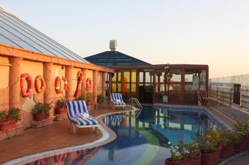 فندق سي فيو دبي في دبي: مسبح مع كرسيين بجانب مبنى