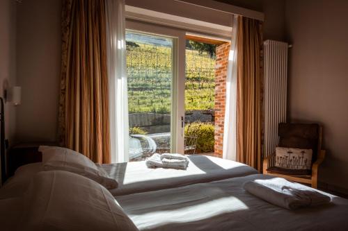 um quarto com uma cama e uma grande janela em Eremo della Gasprina em La Morra