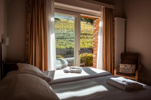 a bedroom with a bed and a large window at Eremo della Gasprina in La Morra