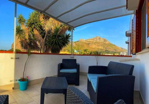 a balcony with chairs and a view of a mountain at Yucca Apartment in San Vito lo Capo