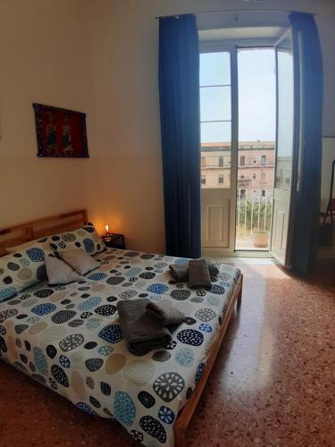 a bedroom with a bed and a large window at DiVino Mare rooms in Siracusa