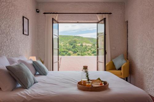 a bedroom with a large white bed with a window at Vivenda Santiago in Sesimbra