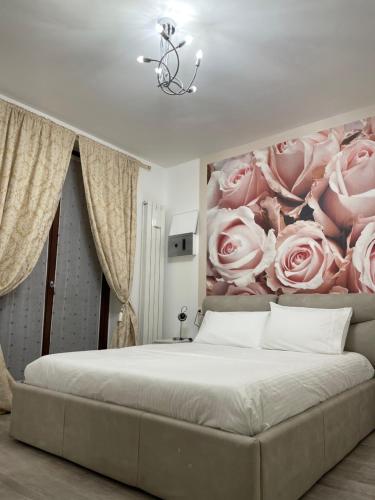 a bedroom with a bed with a painting of roses at casa vacanze esmeralda in Zanica