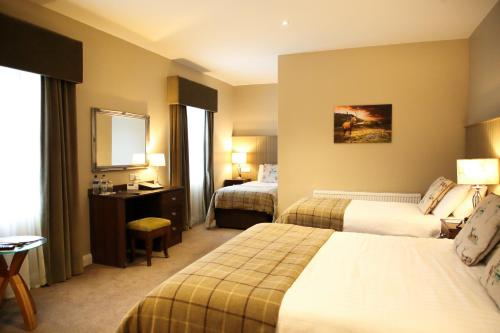 a hotel room with two beds and a mirror at Mulroy Woods Hotel in Milford