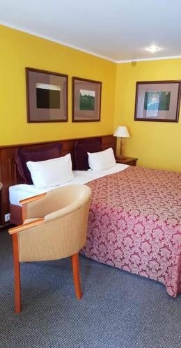 a hotel room with a bed and a chair at Vila Florena Garden in Palanga