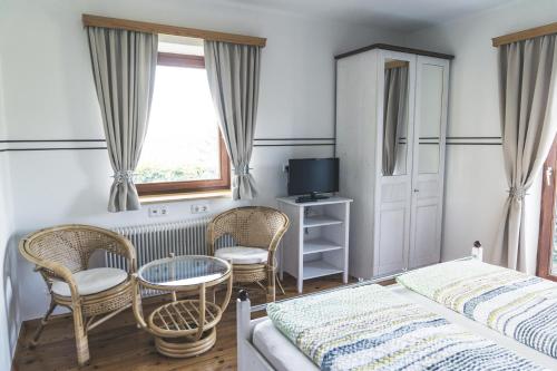 1 dormitorio con 1 cama, mesa y sillas en Wein & Gästehof Erlacher, en Hartmannsdorf