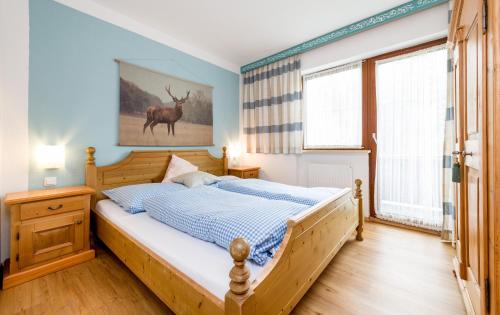 a bedroom with a bed and a deer picture on the wall at Tyrol Appartements in Ehrwald