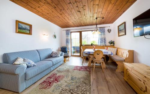 a living room with a blue couch and a table at Tyrol Appartements in Ehrwald