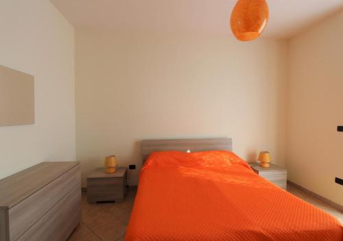 a bedroom with a bed with an orange blanket at Villa Green - Irpinia in Venticano