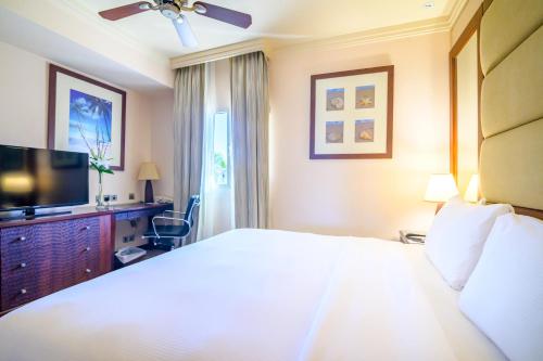 a hotel room with a bed and a flat screen tv at Danat Jebel Dhanna Resort in Jebel Dhanna