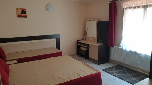 a bedroom with two beds and a desk and a window at Ego Guest House in Belogradchik
