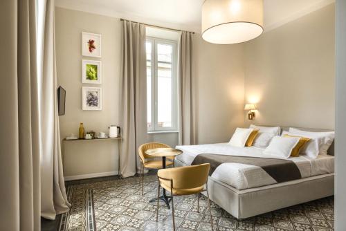 a bedroom with a bed and a table and chairs at Villa La Tuia B&B in Lucca