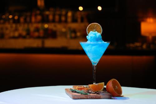 a blue drink sitting on a table with orange slices at Danat Jebel Dhanna Resort in Jebel Dhanna