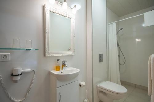 un bagno bianco con un water e un lavandino di Hótel Búrfell a Vík
