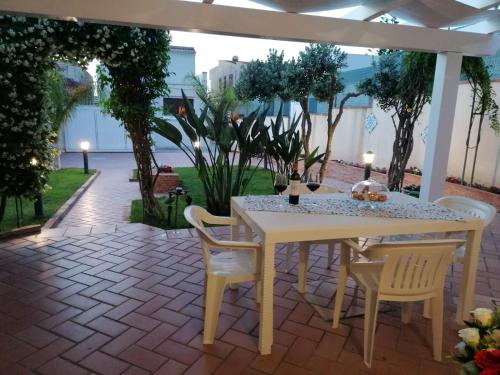 una mesa blanca y sillas en un patio en Villa Sole di Sicilia, en Alcamo Marina