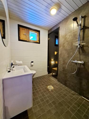 a bathroom with a sink and a shower at Hiekkatupa in Kalajoki