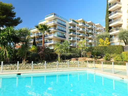 a swimming pool in front of a apartment building at Studio Le Floriana by Interhome in Cannes