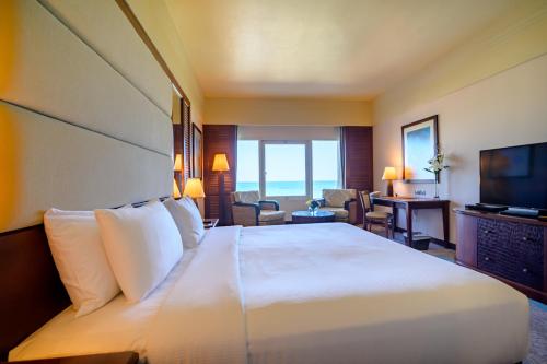 a hotel room with a bed and a television at Danat Jebel Dhanna Resort in Jebel Dhanna