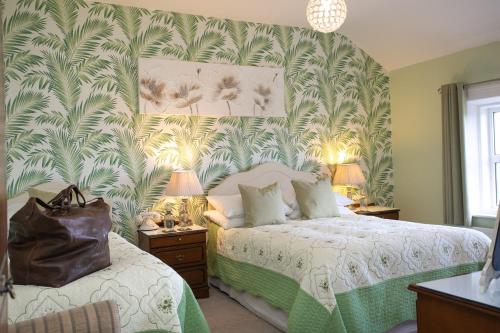 a bedroom with a bed with a green and white wallpaper at Shelleven Guest House in Bangor