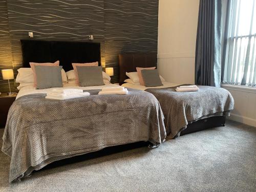 牛頓史都華的住宿－王冠酒店，配有衬衫的酒店客房内的两张床