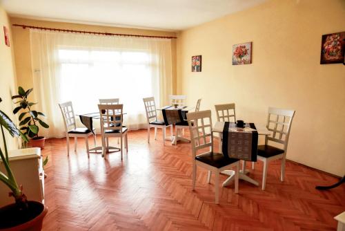 a dining room with tables and chairs and a window at Pensiunea Vila Silva I in Haţeg