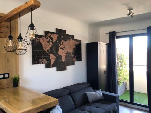 - un salon avec un canapé et une carte du monde sur le mur dans l'établissement Studio climatisé avec balcon face aux arènes d'Arles, à Arles