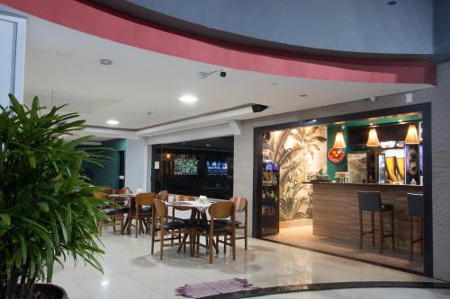 a restaurant with a table and chairs and a bar at Golden Ville Hotel in Marabá