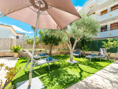 a patio with an umbrella and chairs and a tree at Villa Villa Rosa by Interhome in Port d'Alcudia
