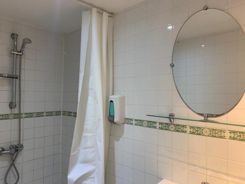 uma casa de banho com um chuveiro e um espelho. em Hotel Du Parlement em Bruxelas
