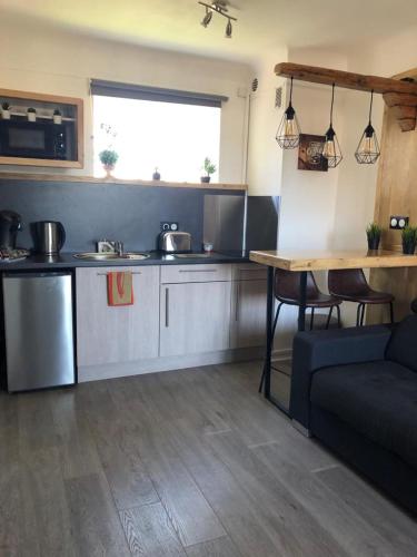 - une cuisine avec un canapé et une table dans une chambre dans l'établissement Studio climatisé avec balcon face aux arènes d'Arles, à Arles