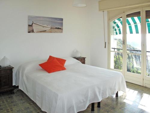 文蒂米利亞的住宿－Apartment Gli Smeraldi by Interhome，卧室配有白色的床和红色枕头