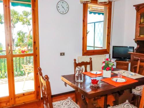 una sala da pranzo con tavolo e orologio sul muro di Apartment Il Nido by Interhome a Vallecrosia