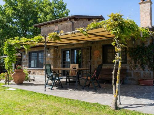 un patio con mesa y sillas bajo una sombrilla en Holiday Home Il Casaletto by Interhome, en Vetralla