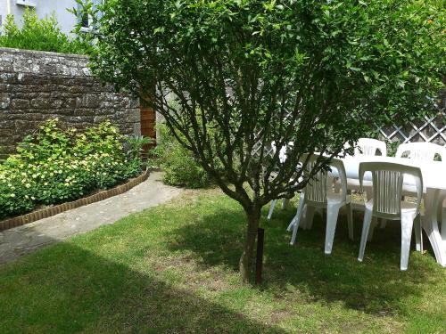 une table et des chaises sous un arbre dans l'herbe dans l'établissement Holiday Home Pasteur by Interhome, à Saint-Malo