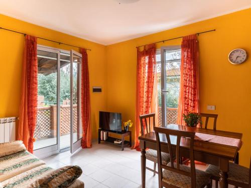 a living room with yellow walls and a table andwindows at Holiday Home Ludovica by Interhome in Soldano
