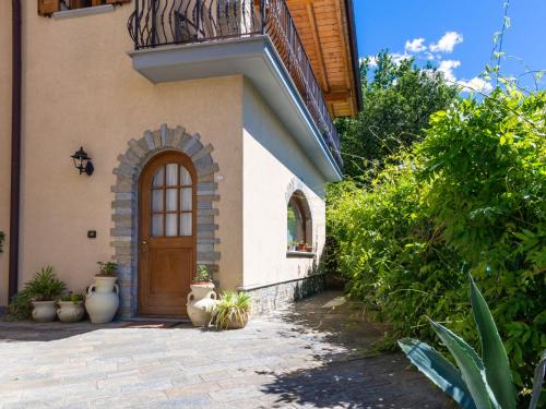 uma casa com uma porta de madeira e algumas plantas em Apartment Fulvia - CCO125 by Interhome em Colico