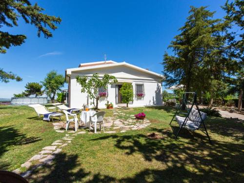 a small white house with a table and chairs in the yard at Holiday Home Masseria Difesa Grande by Interhome in Montenero di Bisaccia