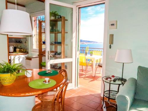 - un salon avec une table à manger et une vue sur l'océan dans l'établissement Apartment Paradise View by Interhome, à Mortola Inferiore