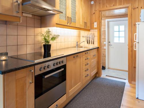 cocina con armarios de madera y fogones en Holiday Home Vindreken - FJS019 by Interhome, en Balestrand