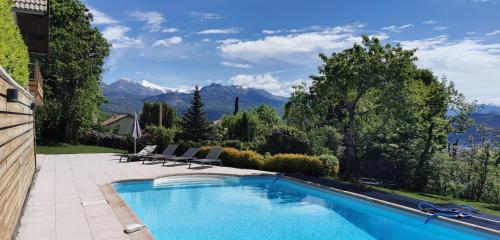 een zwembad met uitzicht op de bergen bij Aux chataigniers alpins in Gap