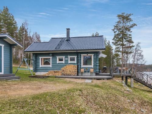 uma casa azul numa colina com um deque em Holiday Home Aurinkotupa by Interhome em Kokkosenlahti