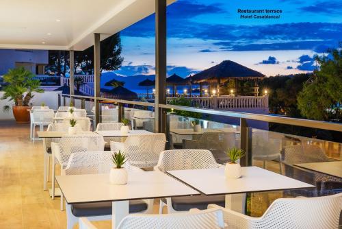 un restaurante con mesas blancas y sillas blancas en Paz y Mar, Santa Ponsa, en Santa Ponsa